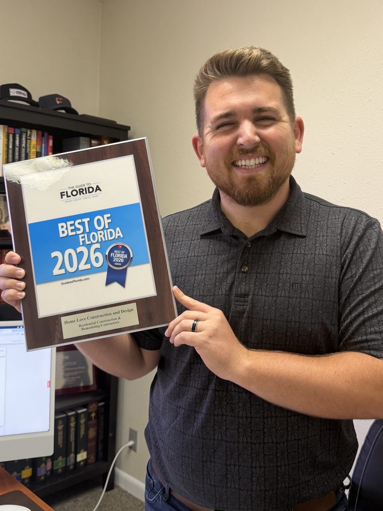 Man holding award plaque and smiling